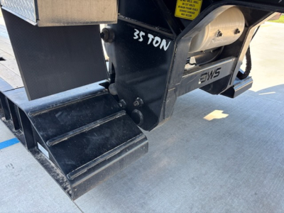 Truck trailer rear end showing 35 TON marking, hitch assembly, and hydraulic components.