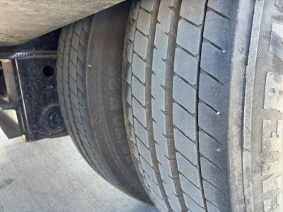 Trailer wheel and tire view showing tire tread and sidewall markings.