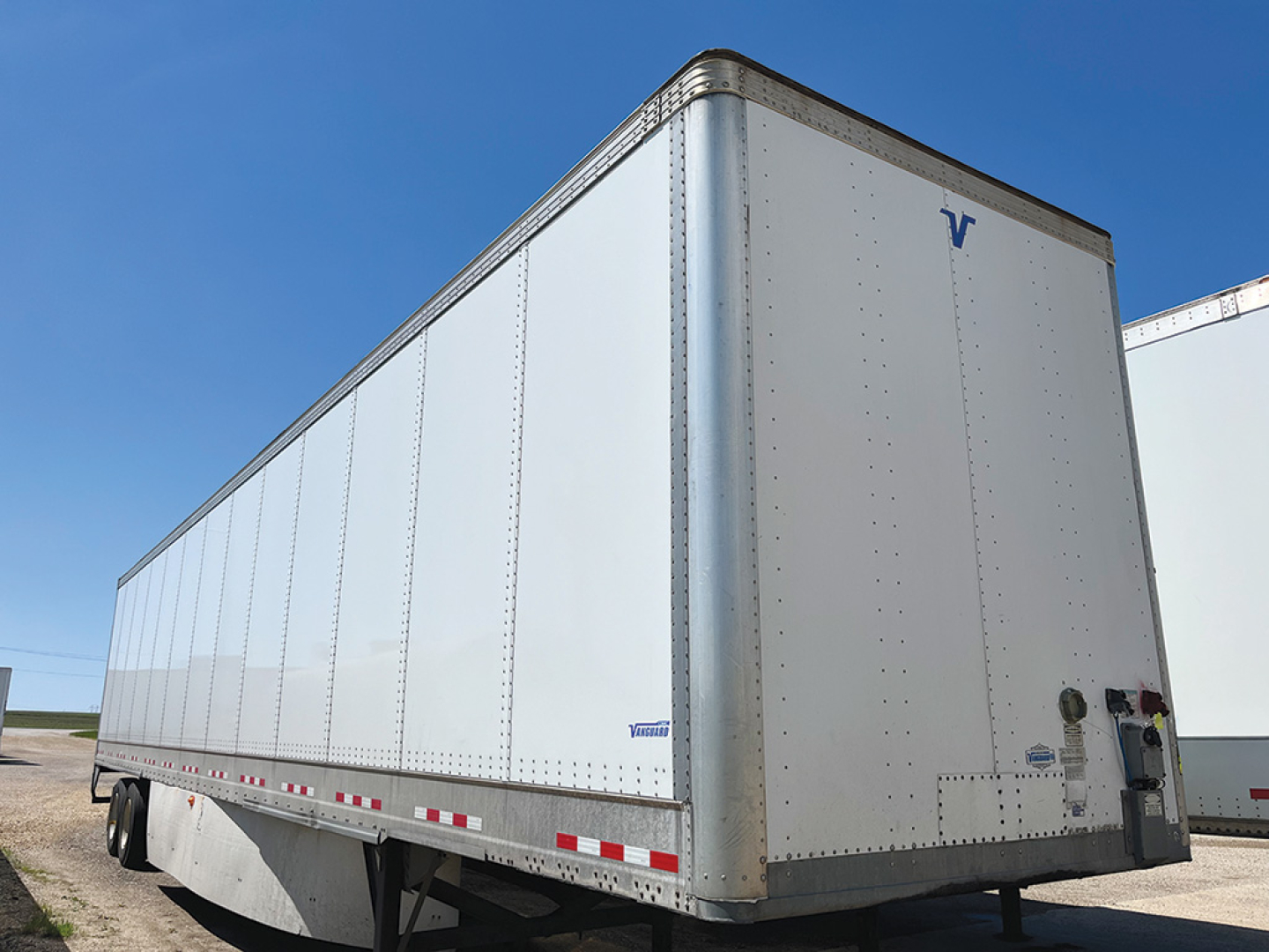 CIMC trailer side and rear showing white box body with Vanguard logo on upper rear corner and rear doors.