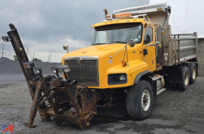 Front three-quarter view of a yellow 2013 International PayStar 5600i dump truck with a snow plow attachment and dump bed visible.