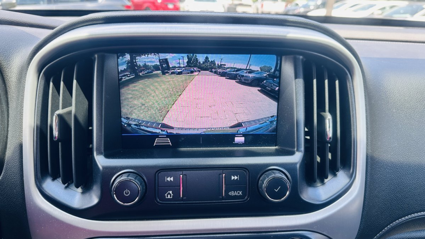 GMC Canyon 2021 interior display showing rearview camera on infotainment screen and climate controls.
