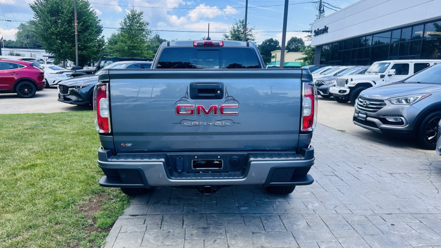 GMC Canyon rear view showing GMC badge and tailgate in a parking lot.