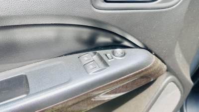 General interior door panel view of a 2021 GMC Canyon showing window/lock controls and a woodgrain trim piece.