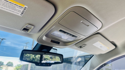 Front interior overhead console and rearview mirror area of a 2021 GMC Canyon showing overhead lights and sun visors.
