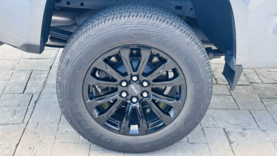 Front left wheel and tire of a 2021 GMC Canyon pickup truck showing alloy rim and tire tread.