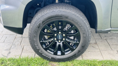 Wheel and tire close-up showing black multi-spoke rim on a GMC Canyon pickups' front wheel well.