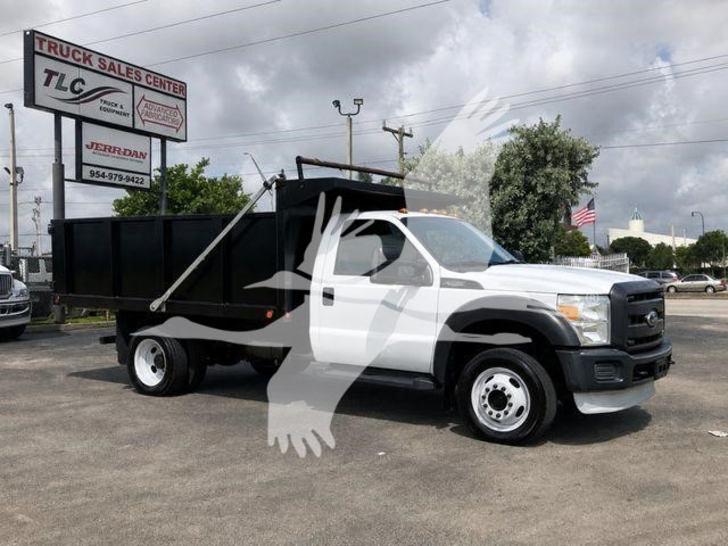 Ford F-450 dump truck in serviceable condition with white cab and black dump bed, showing front grille and side profile.