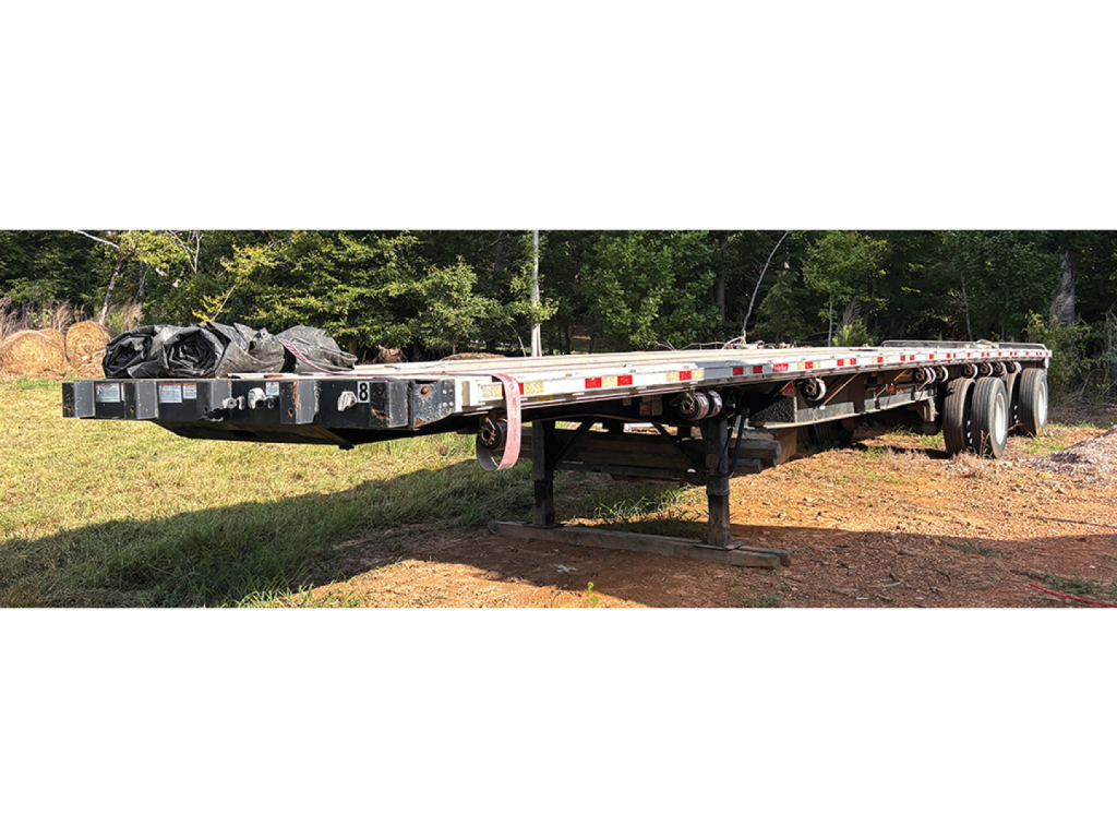 Great Dane aluminum and steel composite flatbed trailer, side view showing long deck, tandem axles, and undercarriage with support legs.