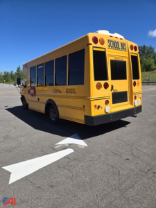 School bus rear and side view showing yellow Chevrolet Express G4500 mini school bus with 'Central School' text on side, 'SCHOOL BUS' sign on rear window, stop lights, and black bumper.