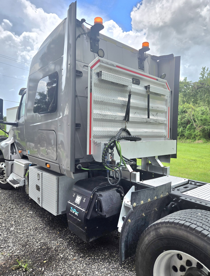 Truck cab rear showing sleeper and attached equipment with storage compartments and dual rear tires.