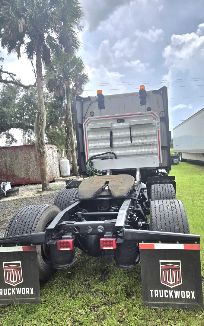 Rear view of a used 2019 International LT625 condo tractor with fifth wheel and dual rear axles, mud flaps labeled TRUCKWORX, and orange clearance lights.
