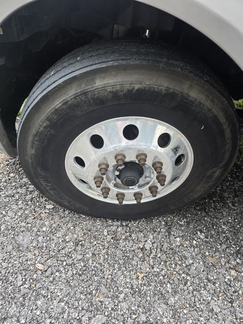 Truck wheel and tire assembly showing lug nuts and steel rim on a 2019 International LT625 condo sleeper.
