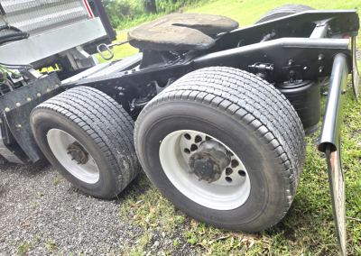 Dual rear tractor-trailer wheels and suspension of a 2019 International LT625 Condo truck showing axles and tire tread.