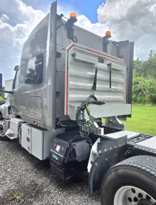 Truck cab rear showing sleeper and attached equipment with storage compartments and dual rear tires.