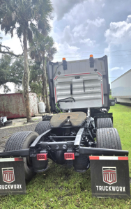 Rear view of a used 2019 International LT625 condo tractor with fifth wheel and dual rear axles, mud flaps labeled TRUCKWORX, and orange clearance lights.