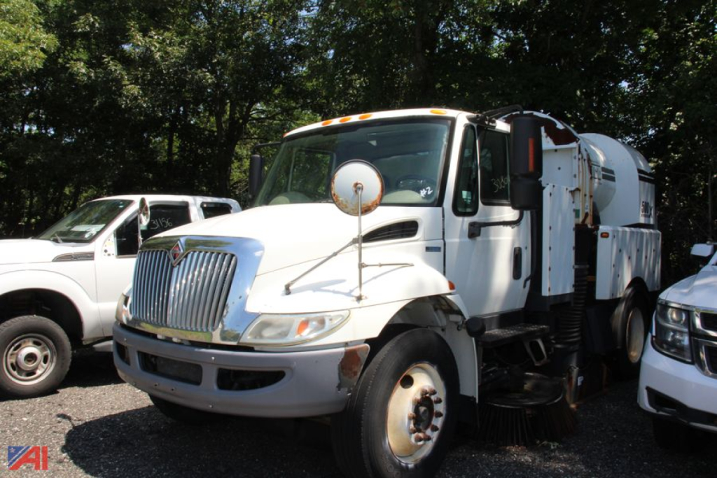 International DuraStar 4300 Tymco sweeper truck in service configuration with large rear sweeper unit, front grille, and side mirrors.