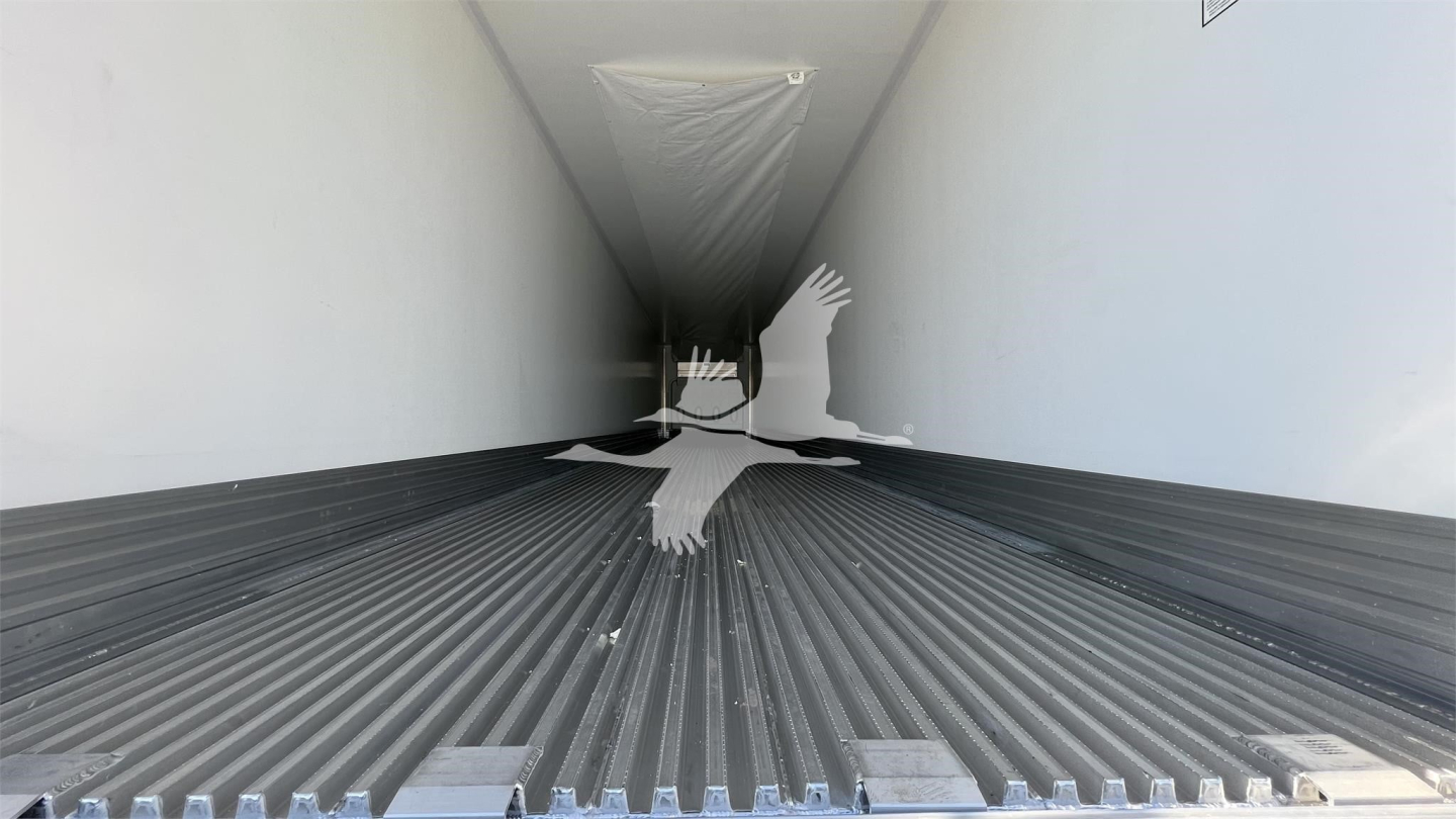 Trailer interior showing ribbed floor and white side walls, with a silhouette of a bird in the middle. No legible labels or numbers visible on the interior.