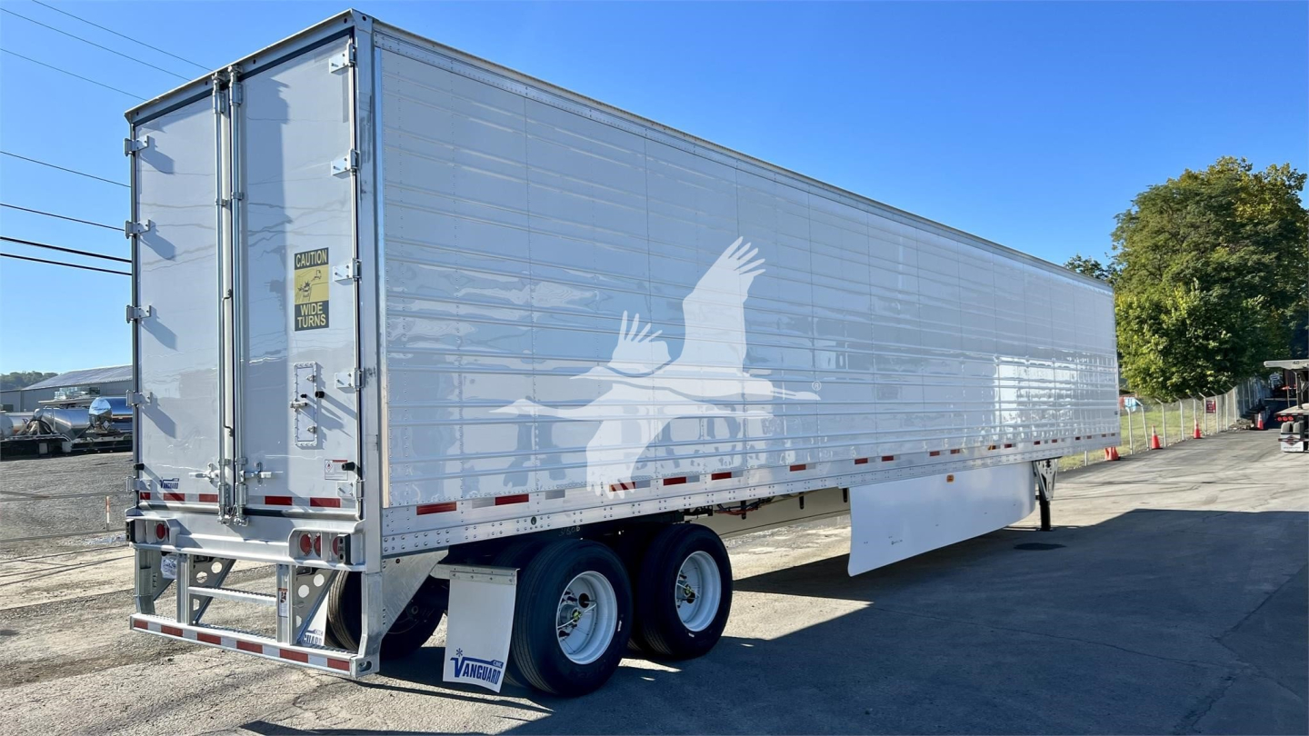 Trailer showing Vanguard Cool Globe reefer with tandem axle and silver exterior; rear doors closed; side informational logos and warning sticker visible.