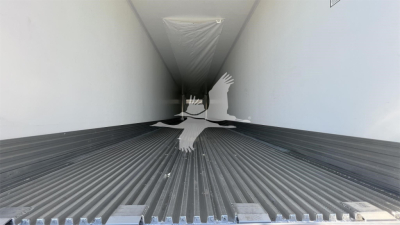 Trailer interior showing ribbed floor and white side walls, with a silhouette of a bird in the middle. No legible labels or numbers visible on the interior.