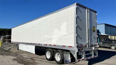 Trailer side and rear showing a Vanguard Cool Globe reefer trailer with white panels, dual rear doors, and dual rear axles.