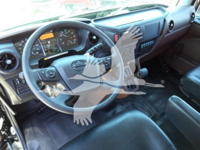 Truck cab interior showing steering wheel, dashboard, and driver seat in a new Hino L6 rollback truck.