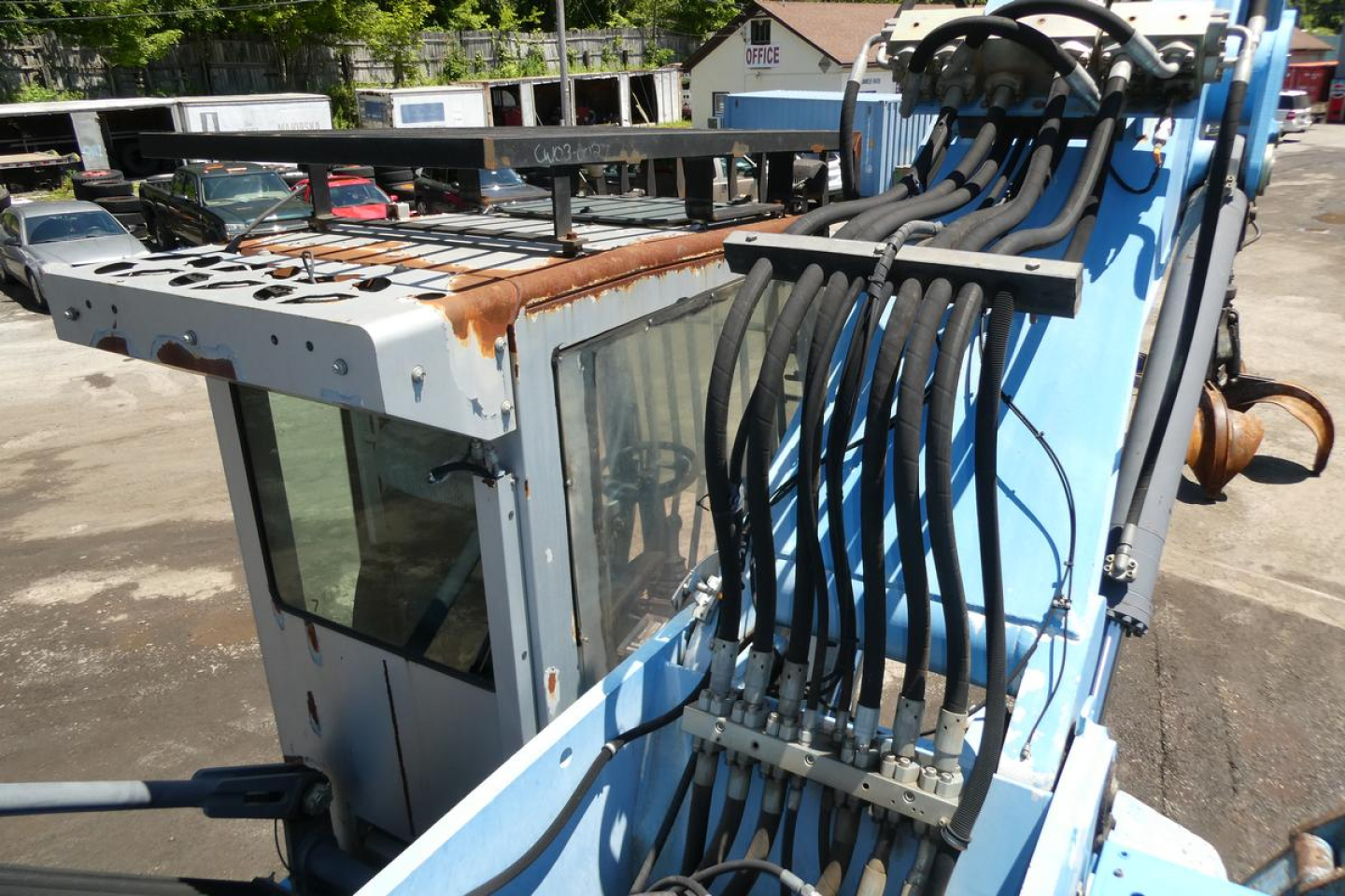 Terex MHL350D boom lift attachment with hydraulic hoses and operator cab in view, shows control hoses and rusted metal surfaces.