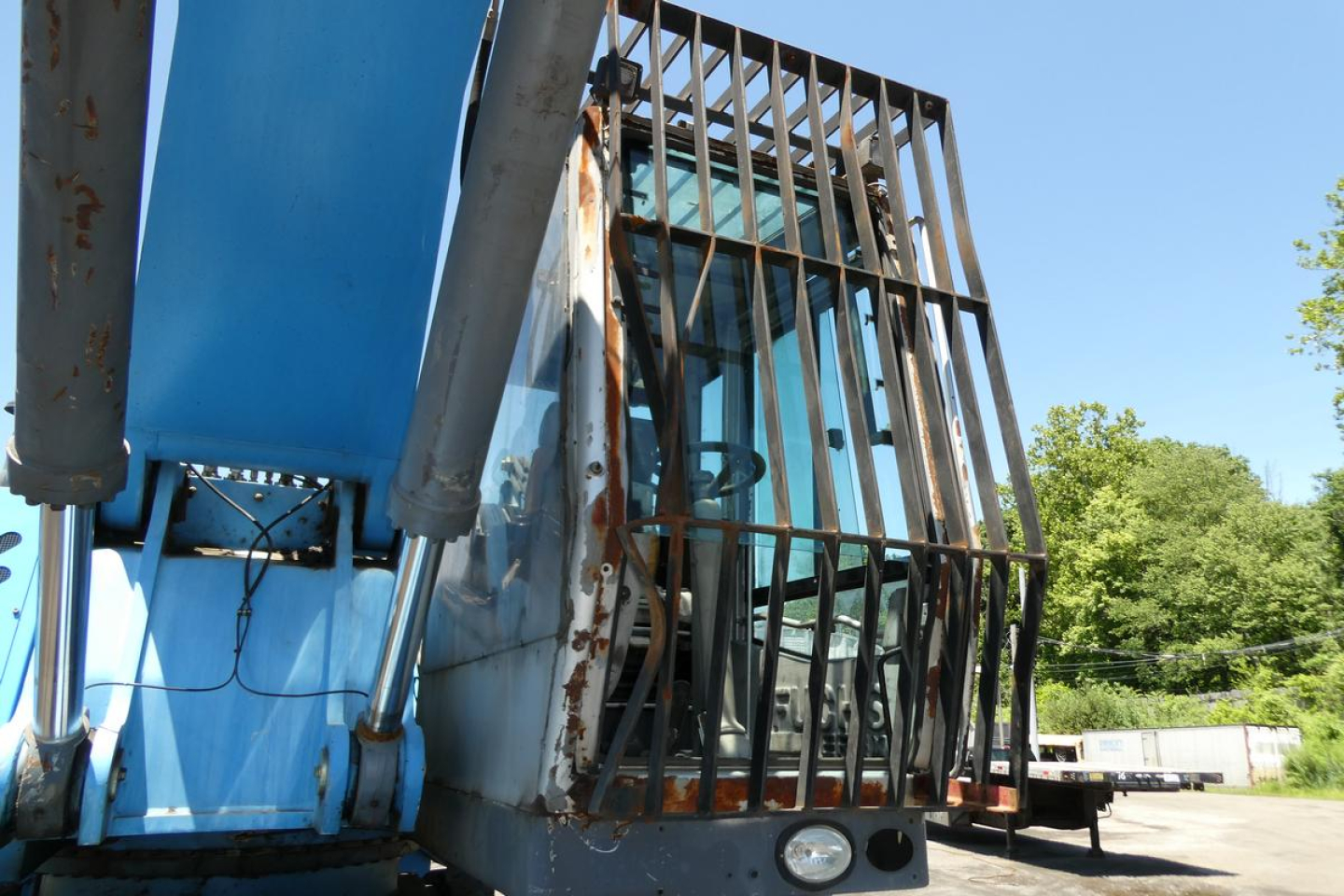 Terex MHL350D boom lift with protective grille and cab, side view showing hydraulic cylinders and blue chassis.