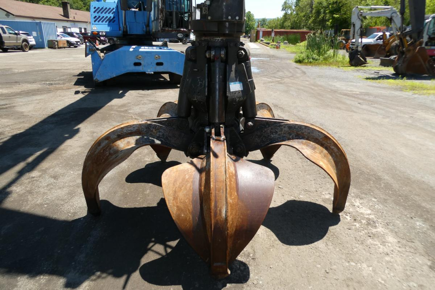 Terex MHL350D hydraulic excavator attachment with prominent rusted grapple/claw bucket in foreground