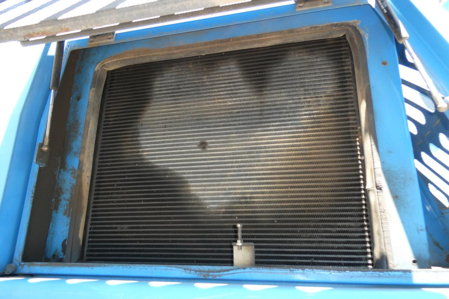 Machine radiator/grill opening of a 2009 Terex MHL350D boom lift showing cooling radiator and surrounding blue frame.