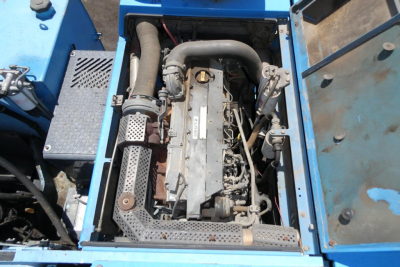 Top view of engine bay in a blue Terex MHL350D showing engine, hoses, and surrounding components.