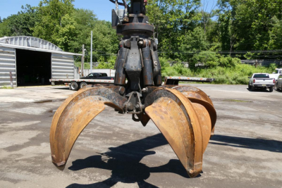 Terex MHL350D grapple attachment with rusted metal claws and hydraulic rotation, front view.