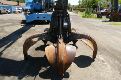 Terex MHL350D hydraulic excavator attachment with prominent rusted grapple/claw bucket in foreground