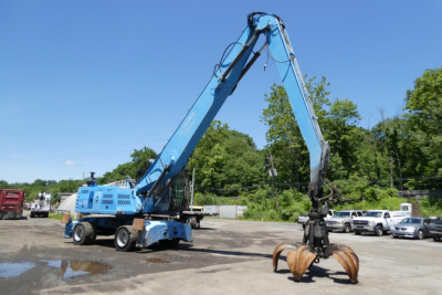 Terex MHL350D hydraulic material handler in blue with long boom and claw grapple in a yard, vintage 2009 model.