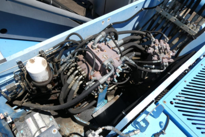 Terex MHL350D equipment engine section showing hydraulic pump manifold and hoses with reservoir.