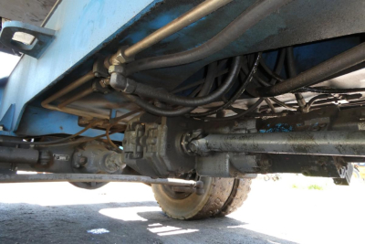 Terex MHL350D undercarriage showing hydraulic hoses and drive components with wheel and axles visible.