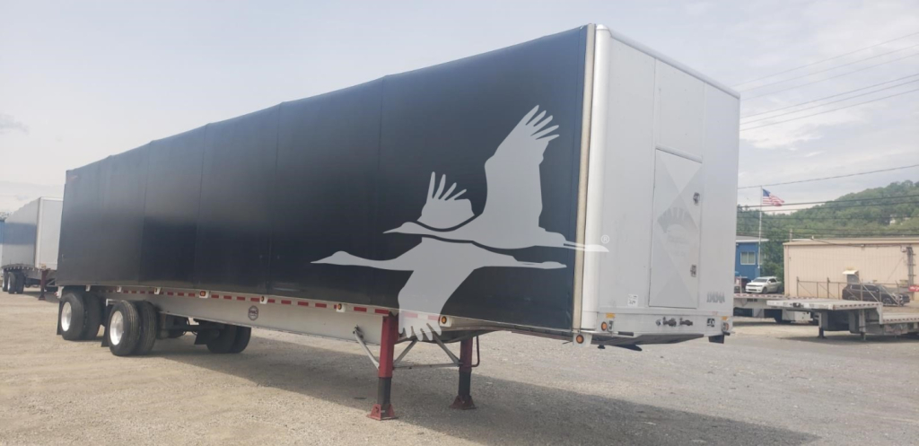 Trailer side view showingCurtainside trailer with graphic of birds in flight and white rear doors.