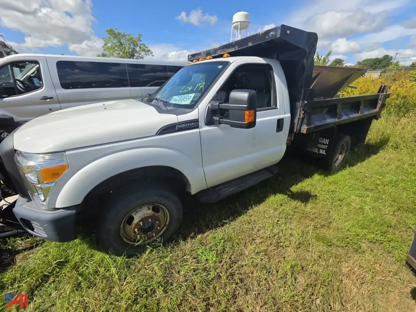 Ford F-350 Super Duty cab and chassis with dump bed plow mounting, front left view showing dual rear wheels and plow setup.