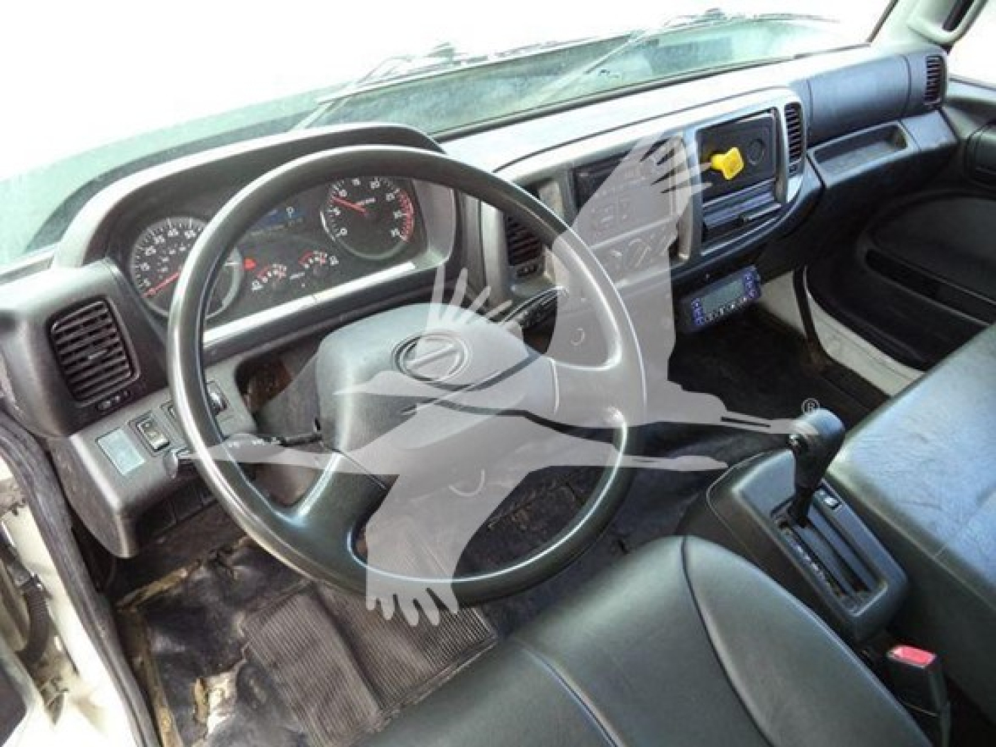 Cab interior of a 2019 Hino 268a refrigerated truck showing steering wheel, dashboard, gear shifter, and driver seat.