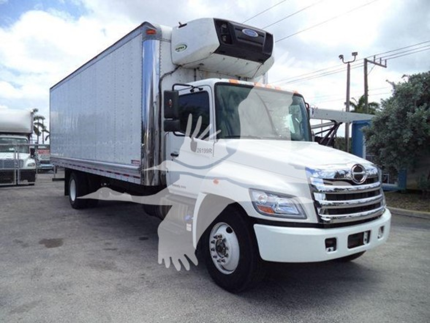 Hino 268a refrigerated truck with a mounted cooling unit on top of the cab and a white cargo trailer.