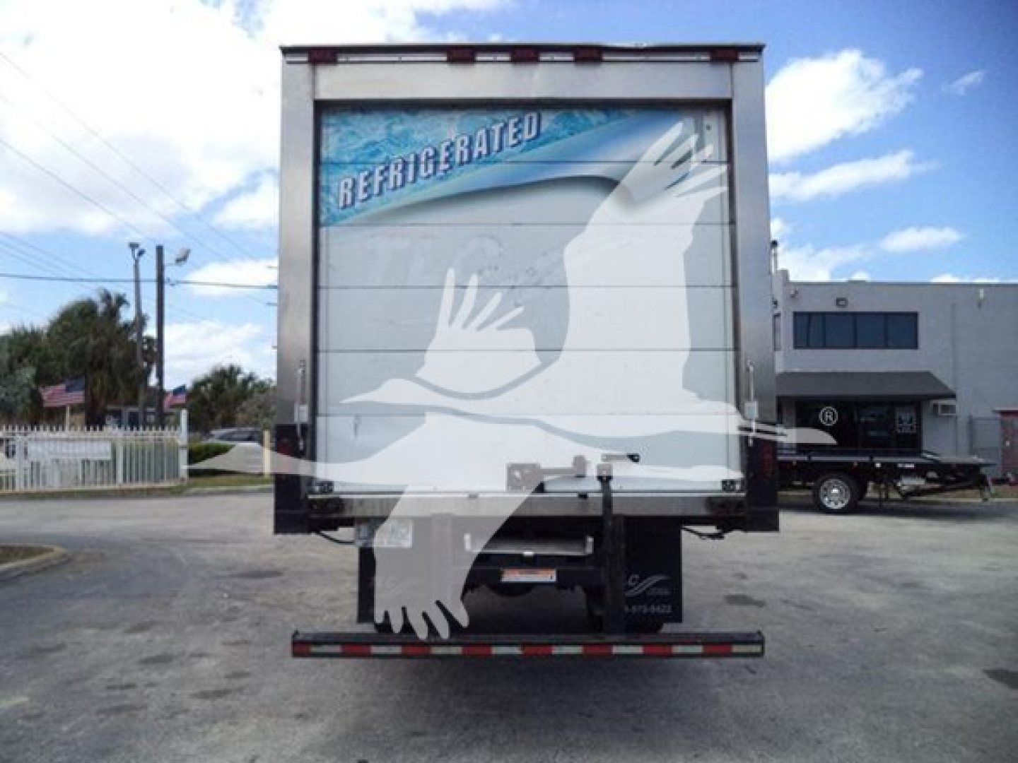 Refrigerated 2019 Hino 268a rear view showing refrigerated truck with eagle logo on closed rear doors and stock number plaque.