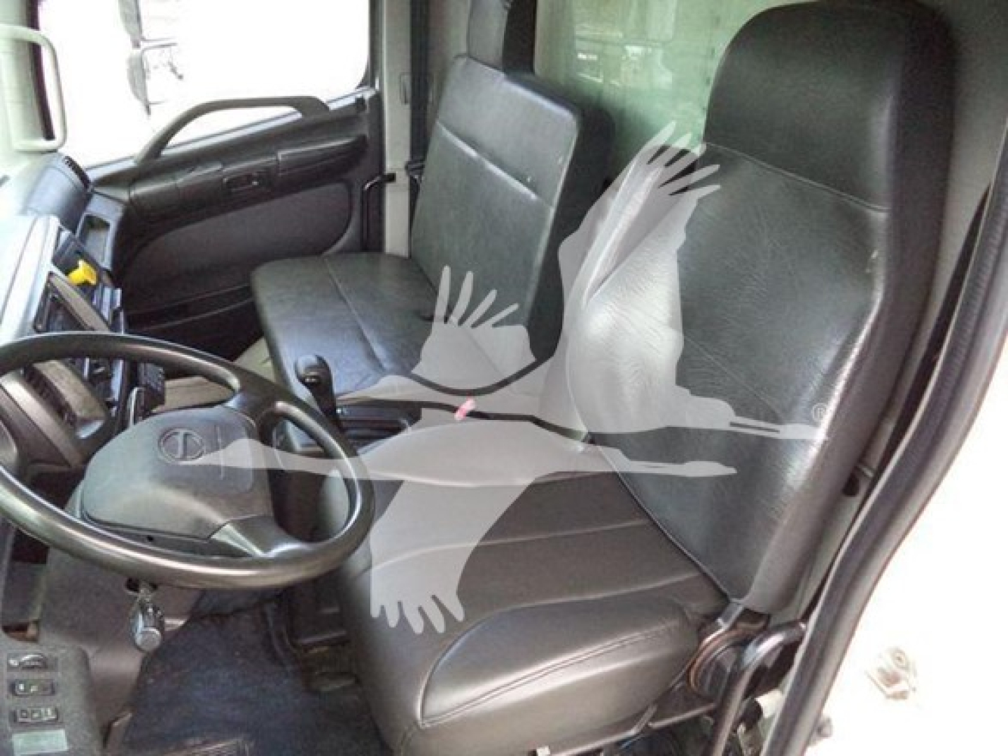 Truck cab interior of a 2019 Hino 268a refrigerated truck showing two front seats, steering wheel, dashboard, and door panels.