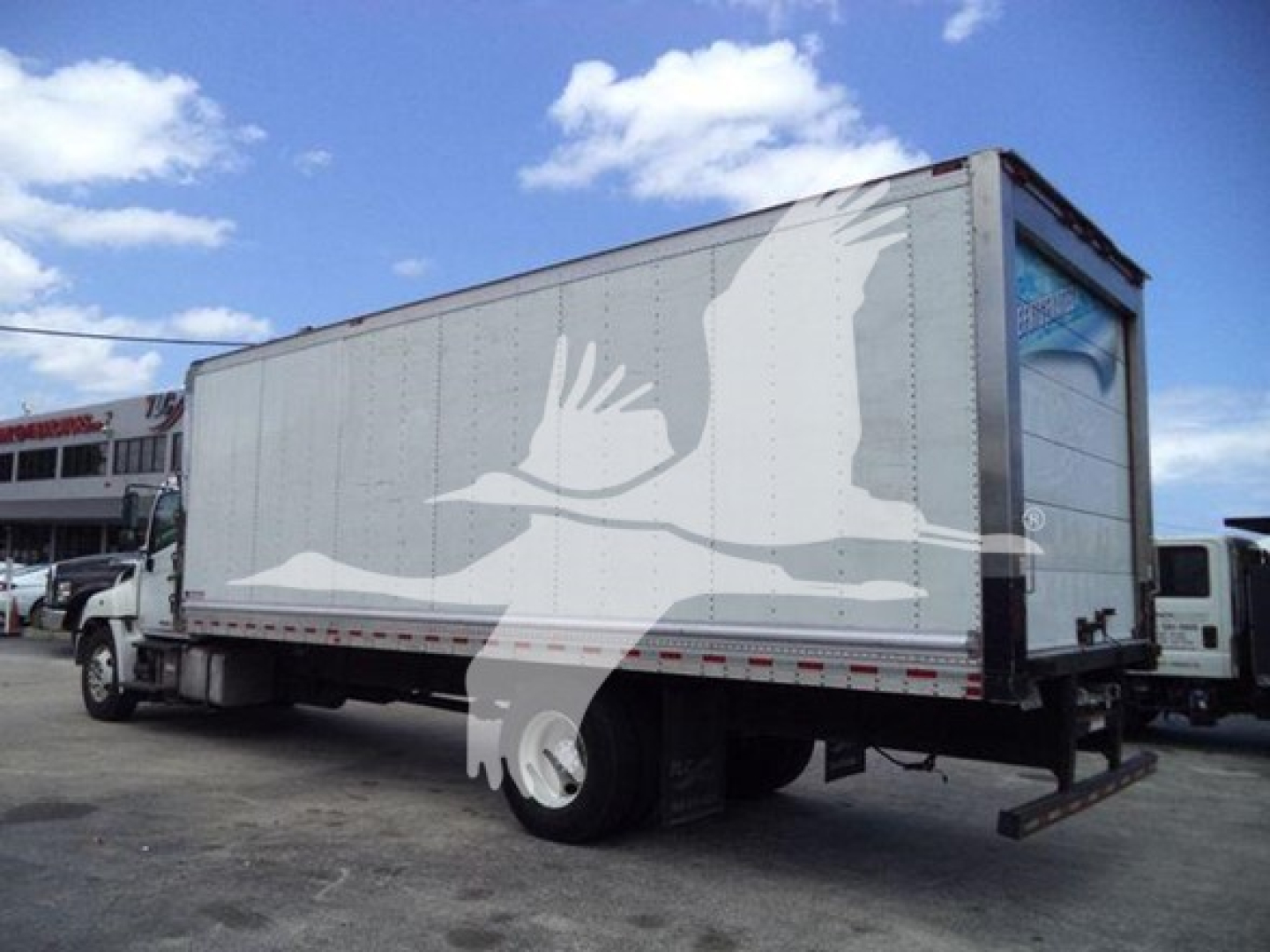 Hino 268a refrigerated truck side view showing cargo box and rear doors with blank white graphics