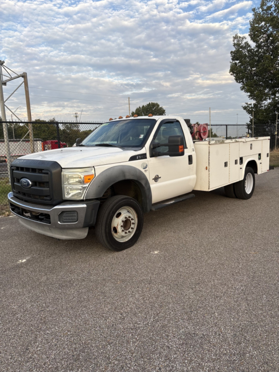 Ford F-550 service/utility truck, white, single cab, utility stake bed with equipment compartments, front view angled, logo visible