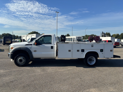 Ford F-550 service body truck side view showing utility compartments, hose reels, and service bed with ladder rack.