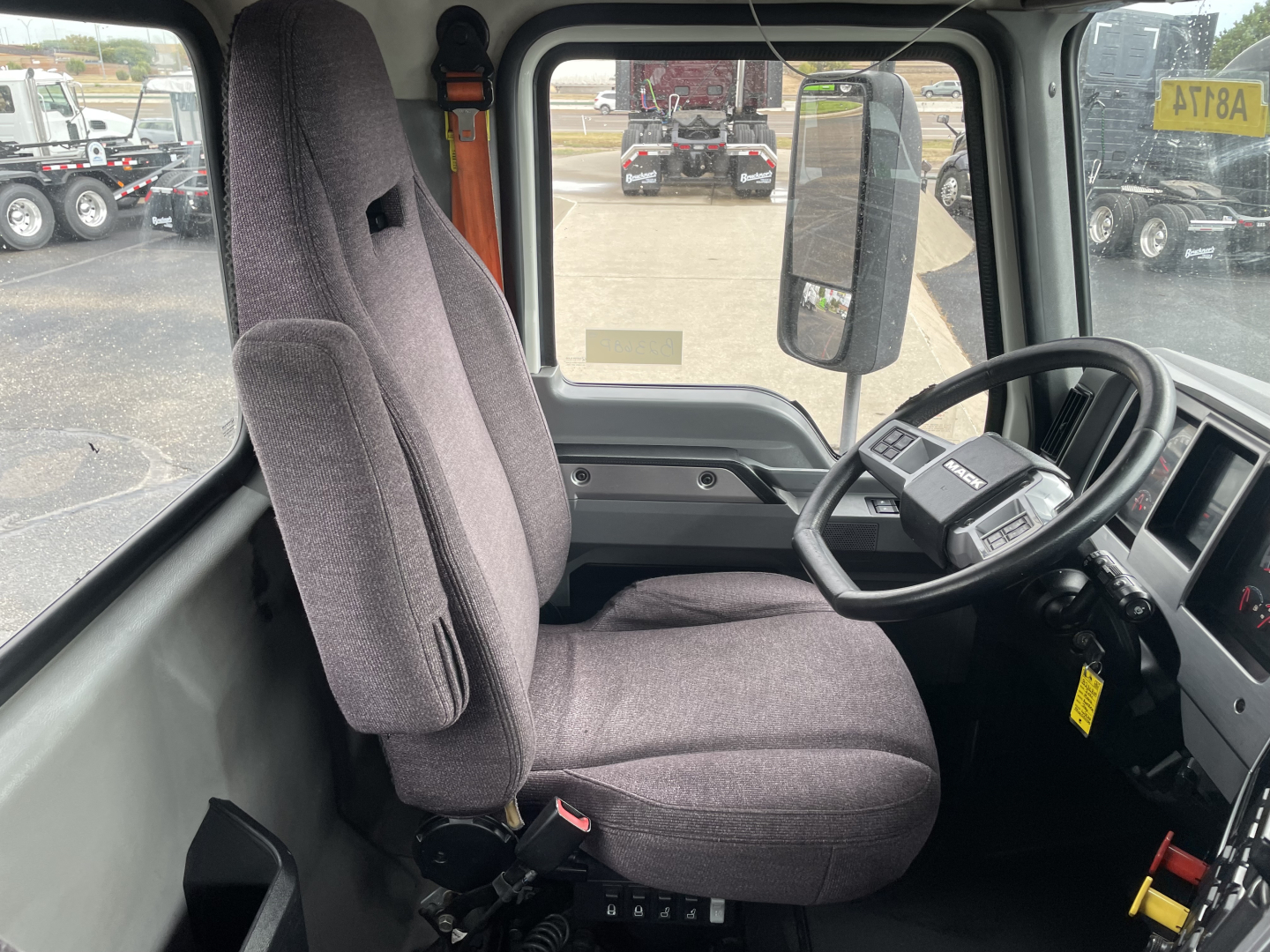 Interior of a 2021 Mack AN64T cab showing driver seat and steering wheel with dashboard and control panel.