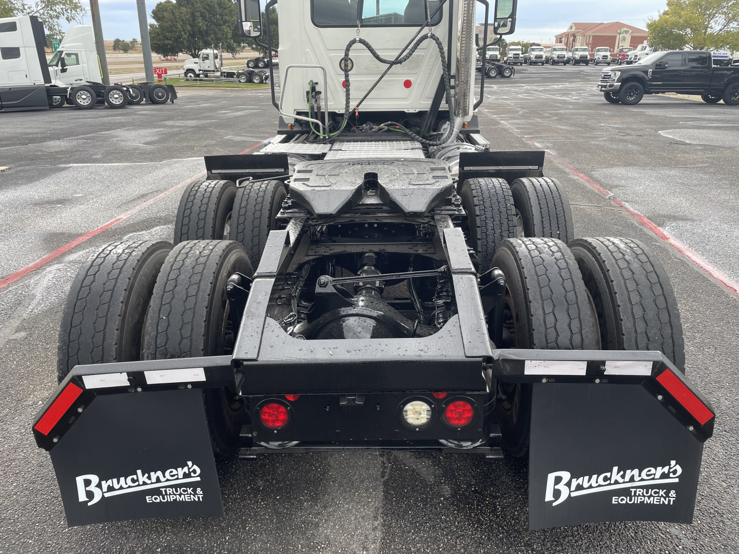 Rear view of a 2021 Mack AN64T daycab truck chassis showing dual rear axle with six tires and mudflaps labeled Bruckner's Truck & Equipment.