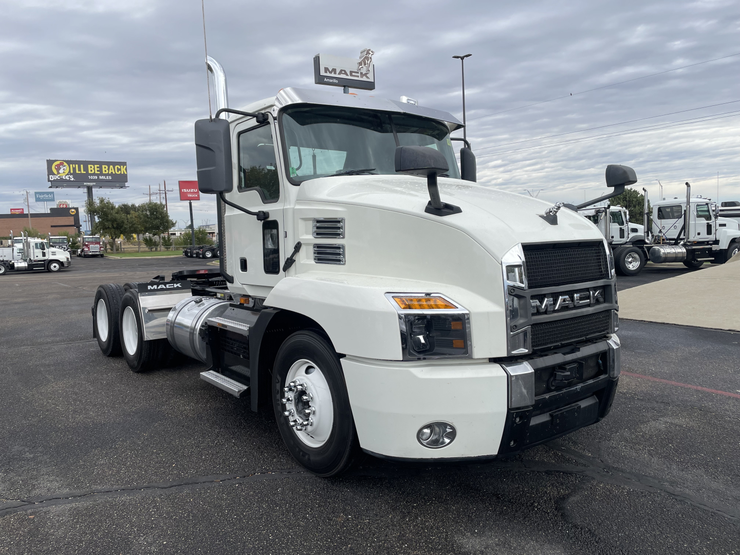 Truck cab showing Mack AN64T engine area with front grille, headlights, and side mirrors; no text visible besides branding on the truck.