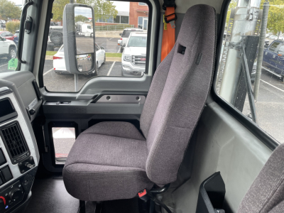 Truck cab interior showing driver seat and dashboard of a 2021 Mack AN64T used conventional daycab.