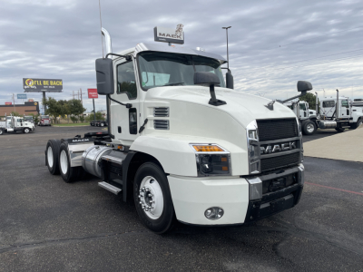 Truck cab showing Mack AN64T engine area with front grille, headlights, and side mirrors; no text visible besides branding on the truck.
