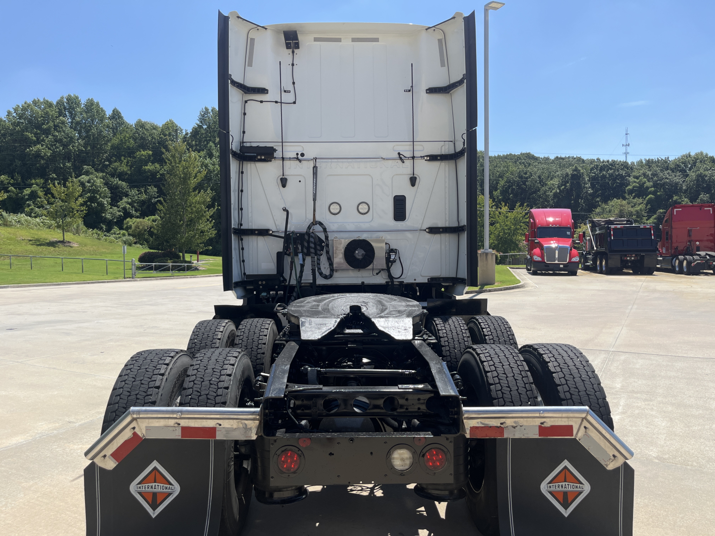 Rear view of a 2021 International LT625 tractor showing dual rear axles, fifth-wheel area, and rear mud flaps with reflective chevron decals.